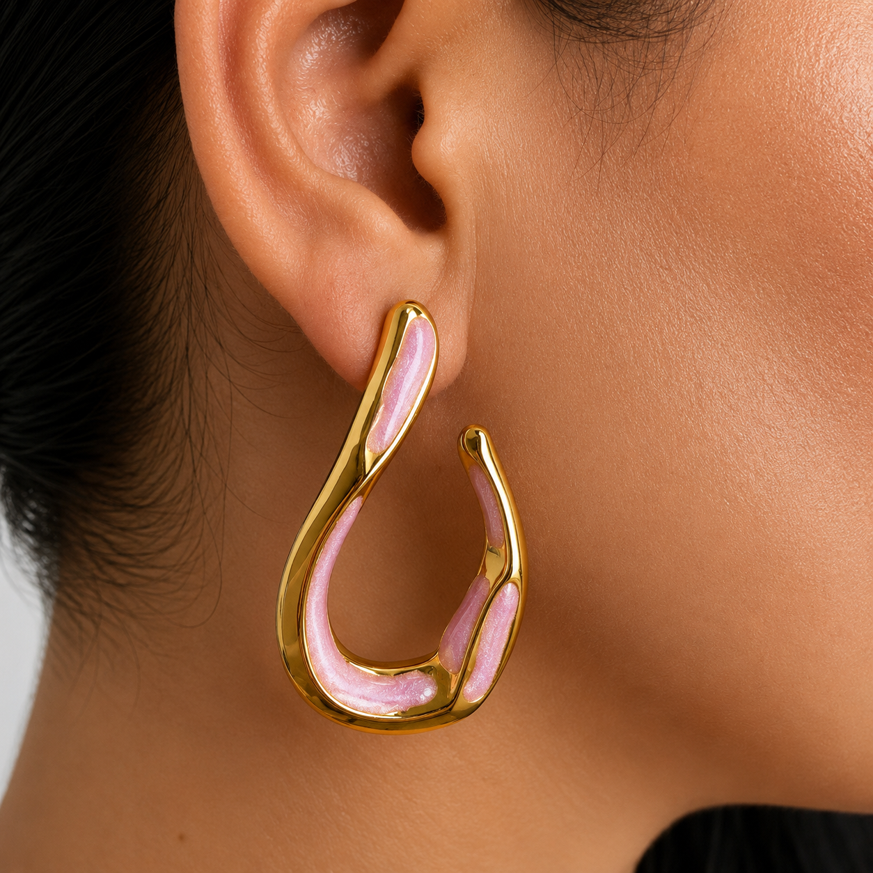 Aretes tipo gota orgánica con acabado dorado e incrustaciones rosa perlado