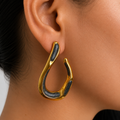 Aretes tipo gota orgánica con acabado dorado e incrustaciones negras